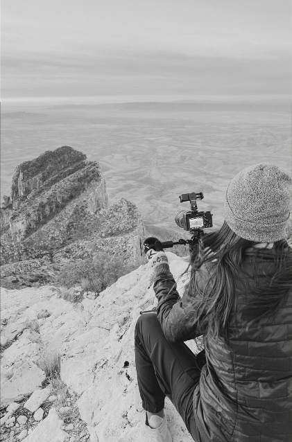 Erica filming on a mountain adventure